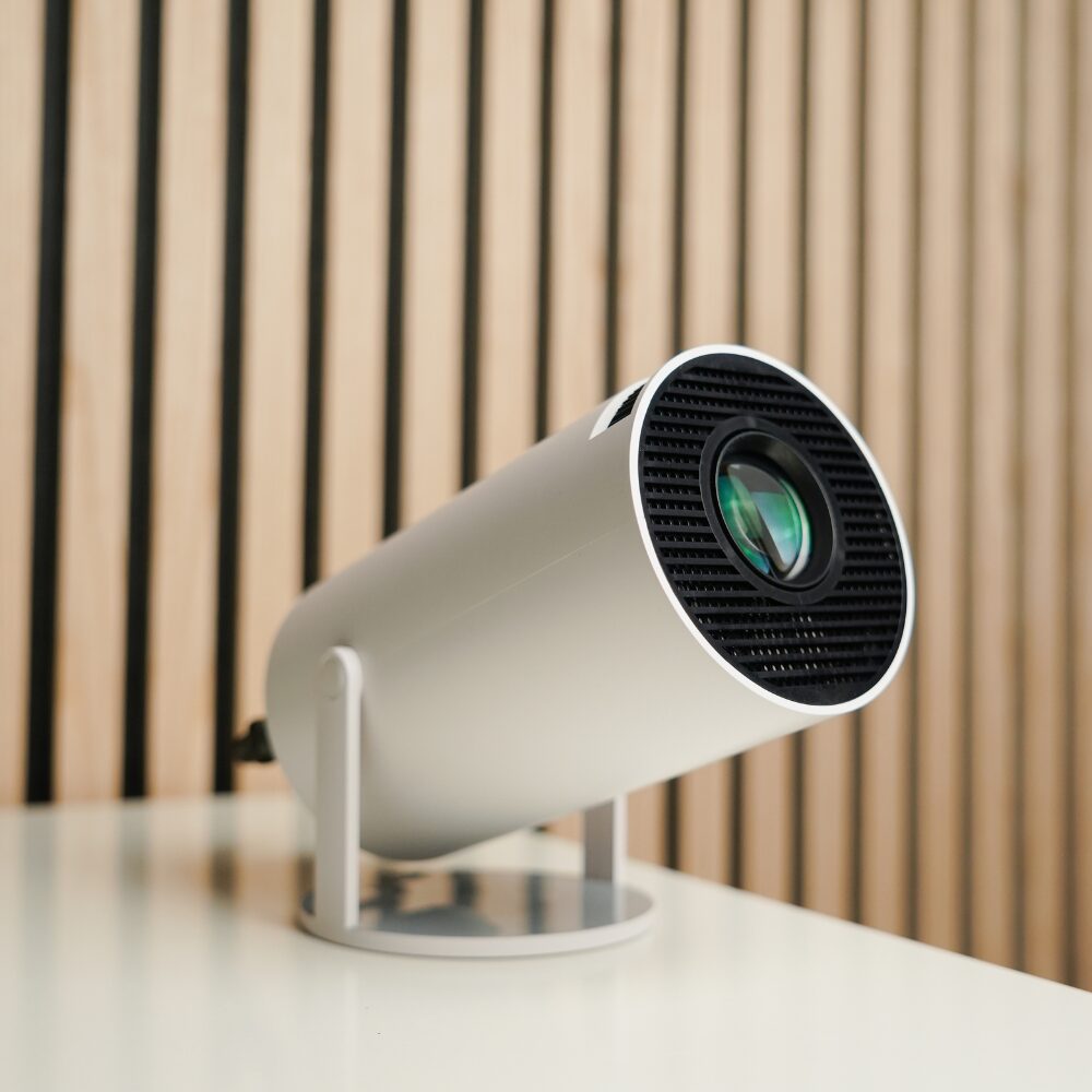 Compact mini projector displayed on a coffee table in a cozy living room